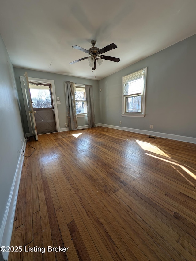 unfurnished room featuring visible vents, baseboards, ceiling fan, and dark wood-style flooring