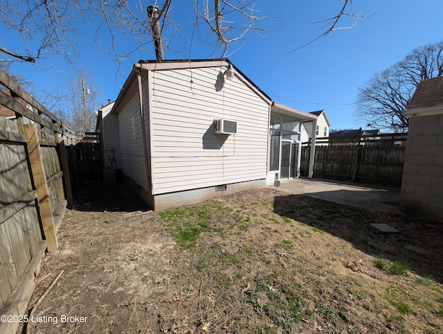 exterior space with crawl space, a patio area, an AC wall unit, and a fenced backyard