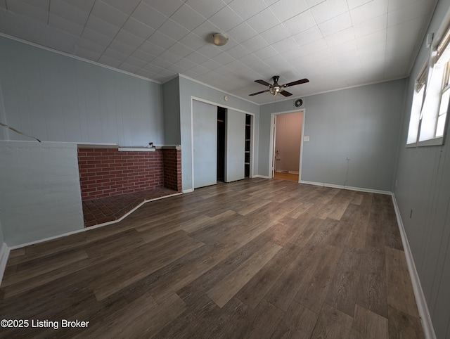 unfurnished bedroom with crown molding, wood finished floors, a closet, and baseboards