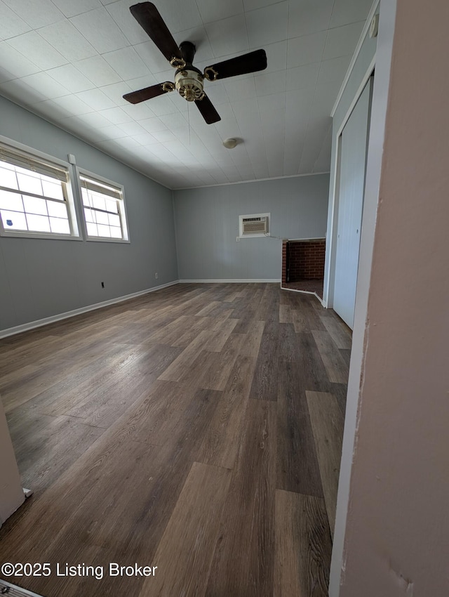 interior space featuring an AC wall unit, wood finished floors, and ceiling fan