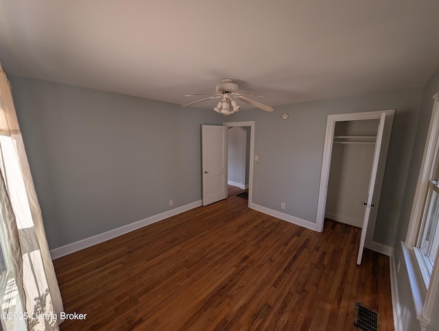 unfurnished bedroom with visible vents, baseboards, dark wood-style flooring, ceiling fan, and a closet