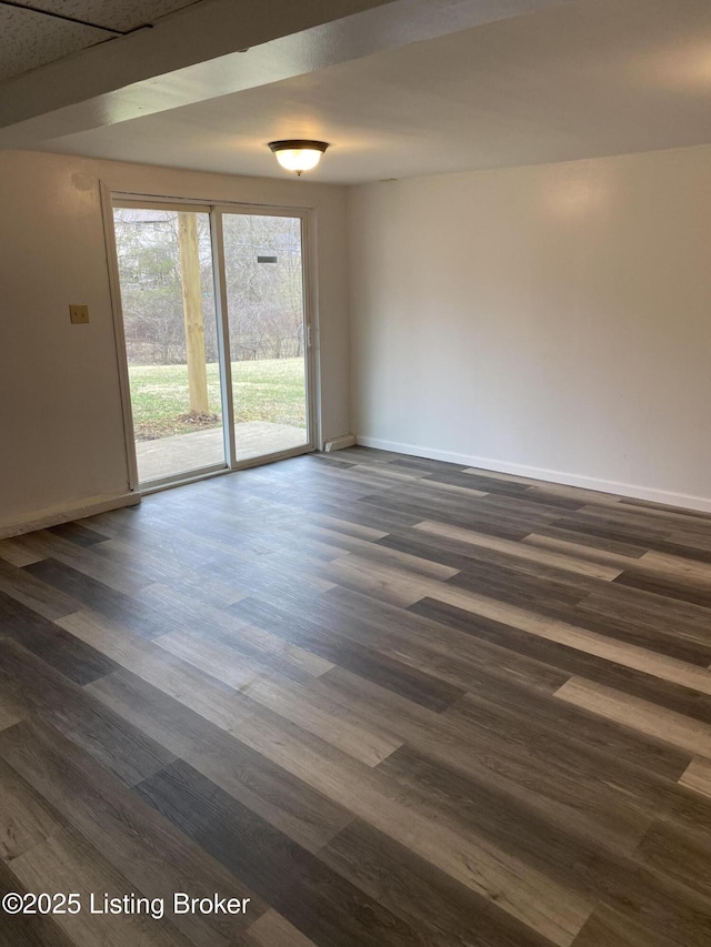 unfurnished room with dark wood finished floors and baseboards