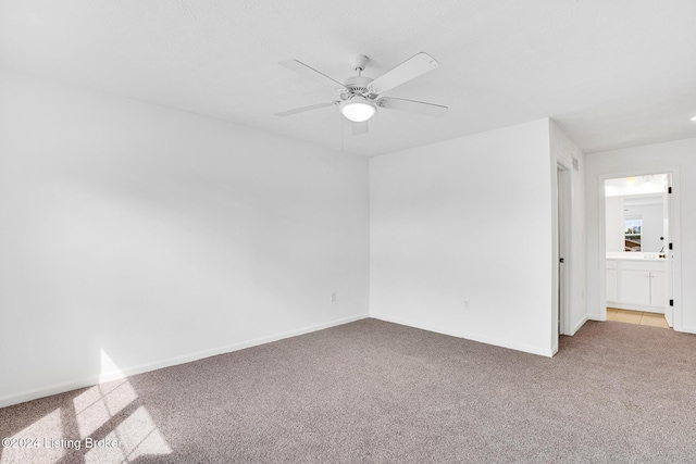 empty room with carpet, ceiling fan, and baseboards