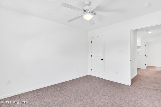 unfurnished bedroom featuring carpet, baseboards, and ceiling fan