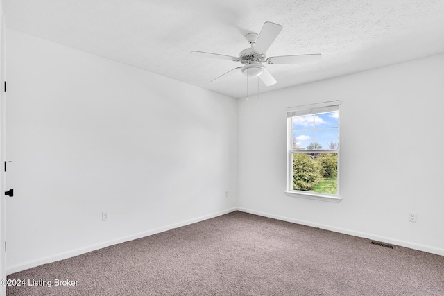 carpeted spare room with baseboards, a textured ceiling, visible vents, and a ceiling fan