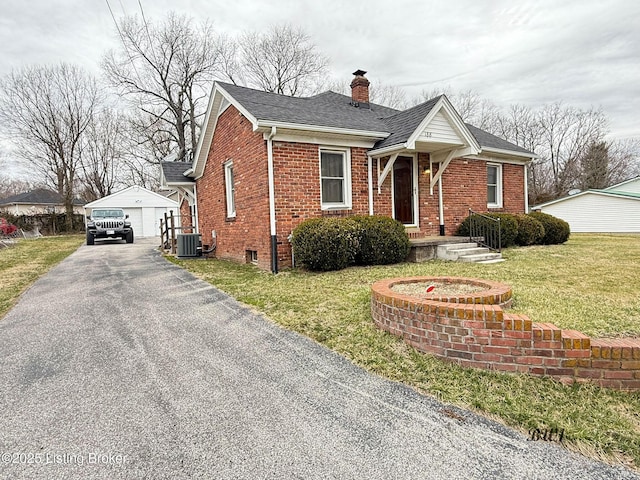 view of front of home with a garage, a chimney, an outbuilding, central AC, and brick siding