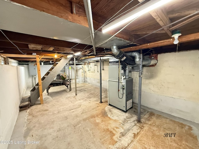 unfinished basement featuring heating unit and electric panel