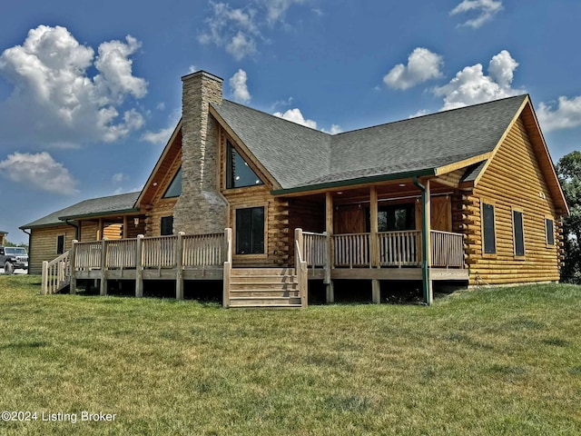 rear view of house with roof with shingles, a lawn, a chimney, and log siding