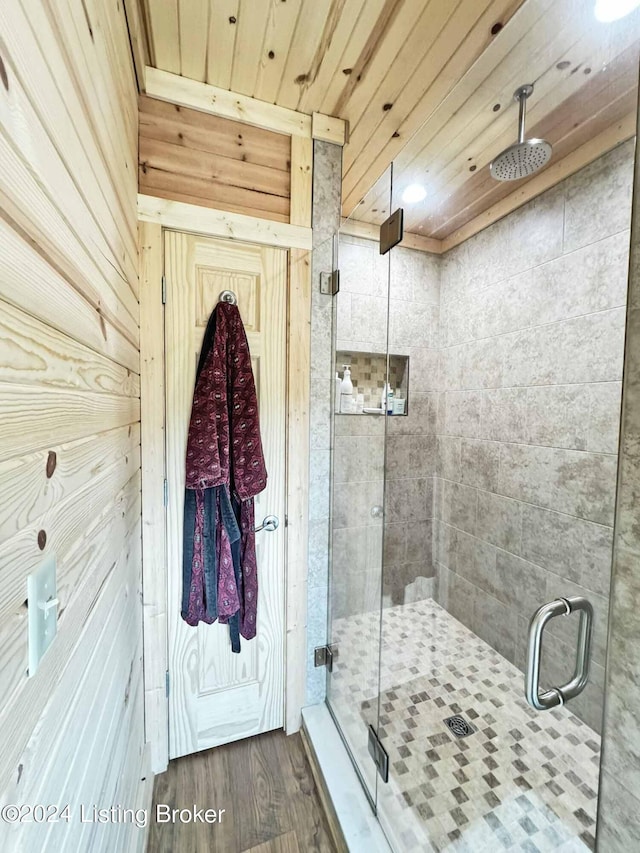 bathroom featuring wooden ceiling, a shower stall, and wood finished floors