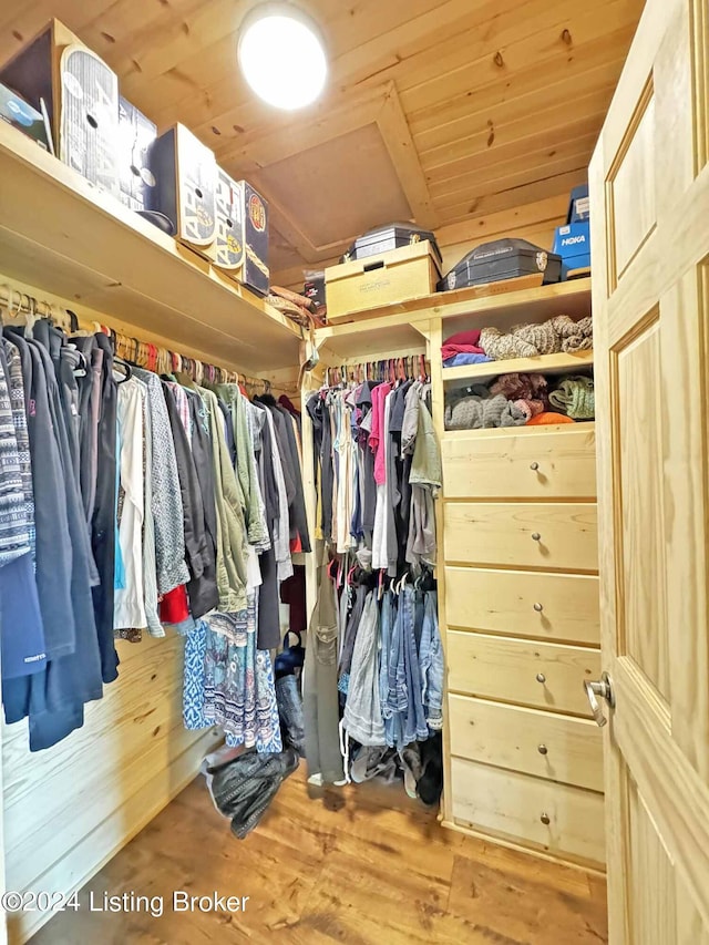 spacious closet with lofted ceiling and wood finished floors