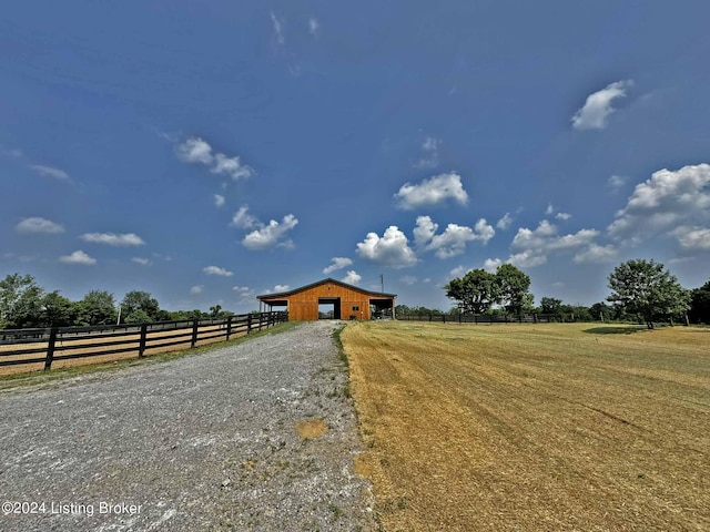 view of road featuring an outbuilding, a rural view, and driveway