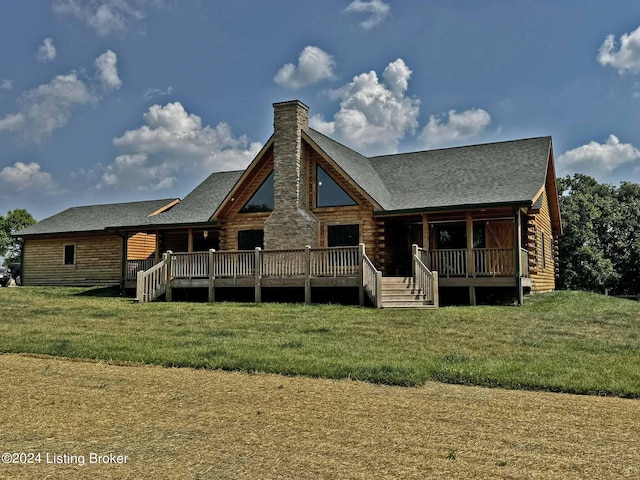 back of house featuring a yard, a chimney, and log siding