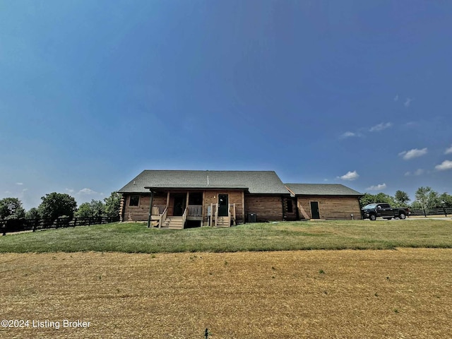 view of front of home with covered porch, fence, and a front lawn