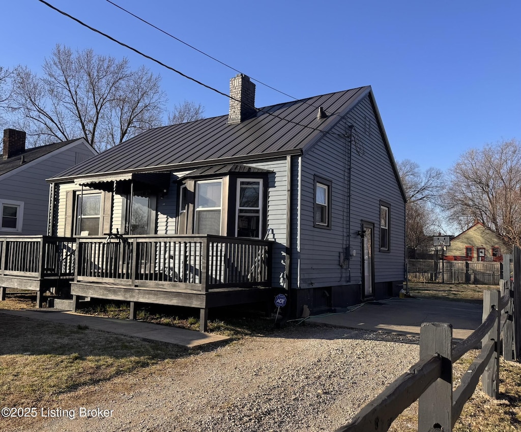 view of front of property with metal roof, a standing seam roof, and a chimney