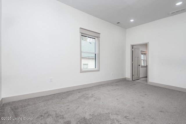 carpeted spare room featuring recessed lighting, visible vents, and baseboards