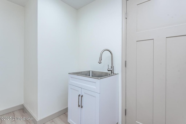 bathroom with vanity, wood finished floors, and baseboards