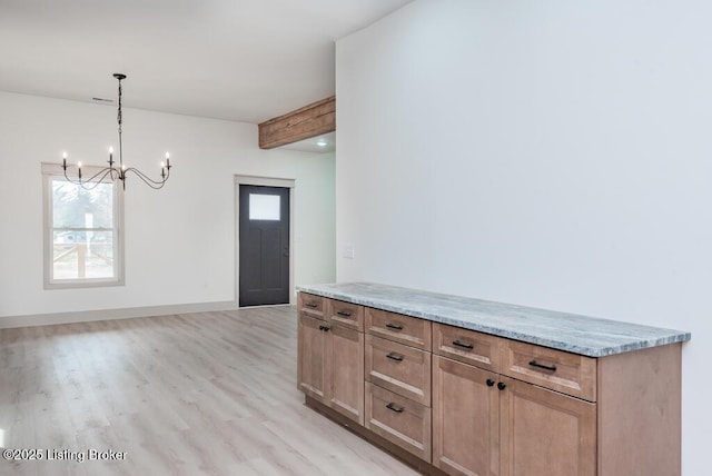 interior space featuring a wealth of natural light, a chandelier, light wood finished floors, and baseboards