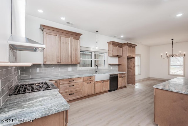 kitchen featuring decorative backsplash, light brown cabinetry, light wood-style floors, wall chimney exhaust hood, and cooktop