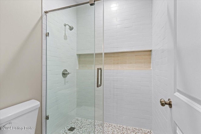 bathroom featuring a stall shower and toilet