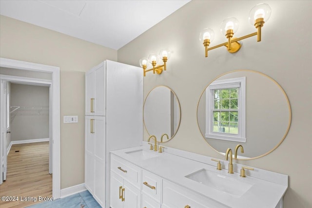 bathroom featuring double vanity, baseboards, and a sink