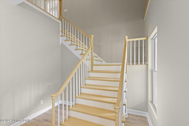 stairway with baseboards and wood finished floors