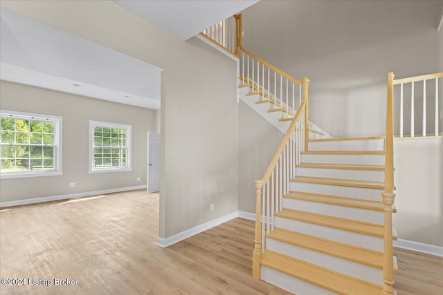 stairs with wood finished floors and baseboards