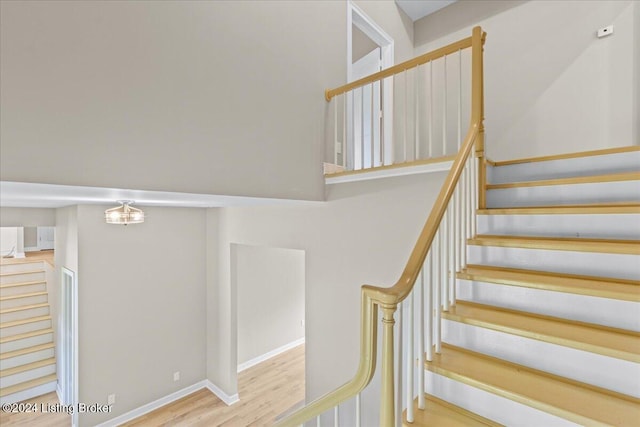 staircase with wood finished floors and baseboards