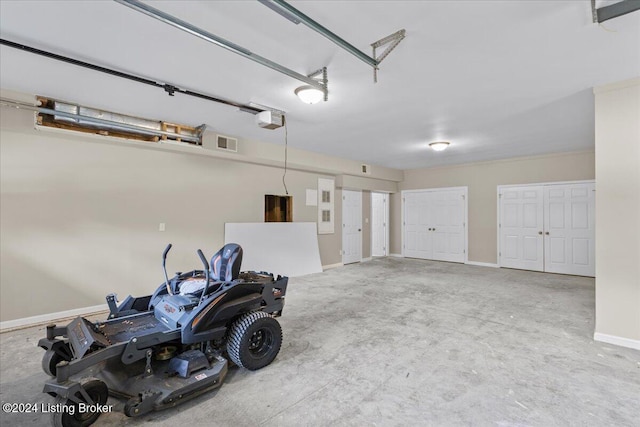 garage featuring a garage door opener, visible vents, and baseboards