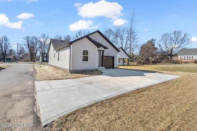 view of front facade with a garage, a front yard, and concrete driveway