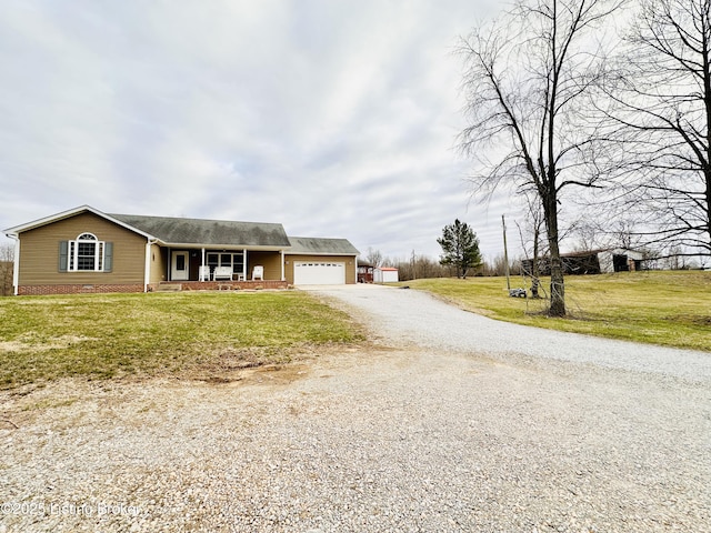 view of front of house with a front yard, covered porch, a garage, and driveway