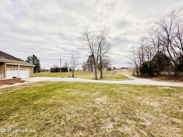 view of yard with a garage and driveway