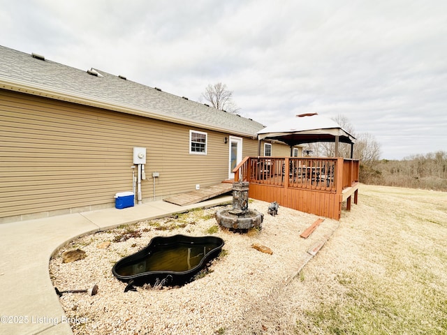 back of house featuring a gazebo, a wooden deck, and roof with shingles