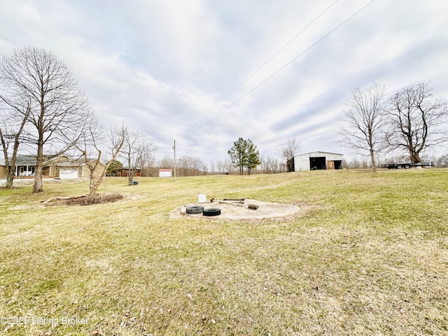 view of yard with an outbuilding and an outdoor fire pit