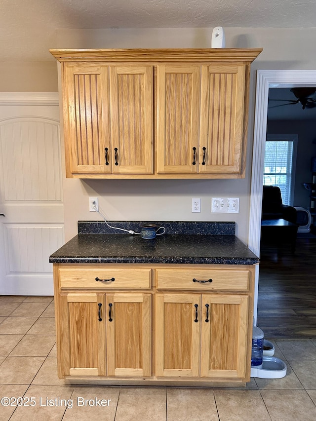 kitchen featuring light tile patterned flooring and dark stone counters