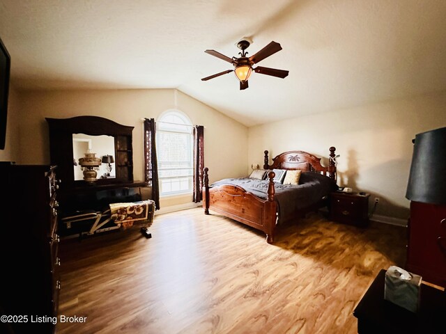 bedroom featuring a ceiling fan, vaulted ceiling, and wood finished floors