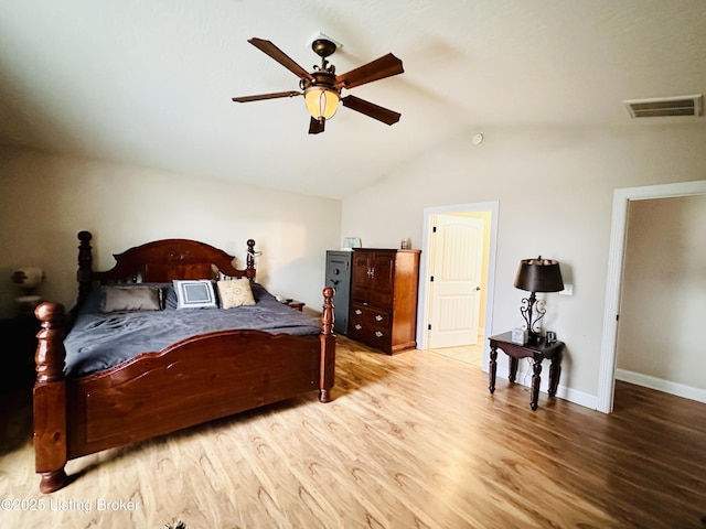 bedroom with visible vents, ceiling fan, baseboards, vaulted ceiling, and wood finished floors