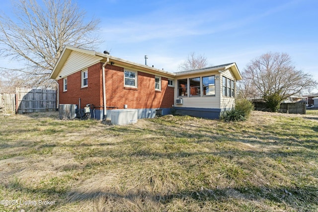 back of property with a yard, fence, and brick siding