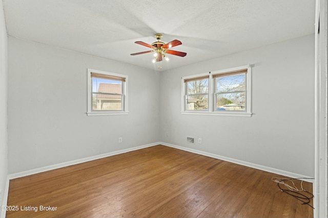 spare room with wood-type flooring, ceiling fan, and baseboards