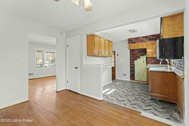 kitchen with baseboards, visible vents, parquet floors, light countertops, and a sink