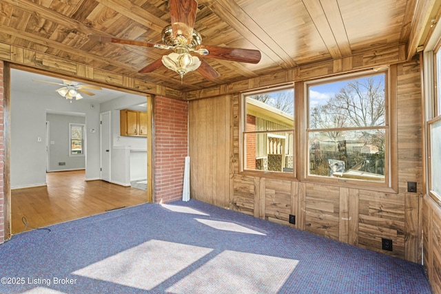 unfurnished room with wooden ceiling and wood walls