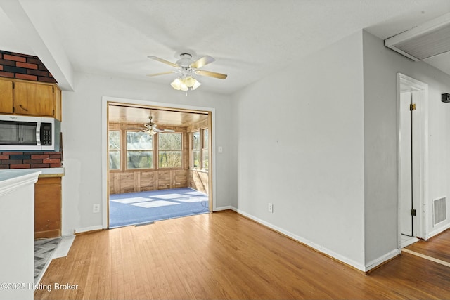 unfurnished dining area with ceiling fan, wood finished floors, visible vents, and baseboards