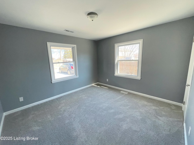 unfurnished room featuring baseboards, carpet flooring, visible vents, and a healthy amount of sunlight