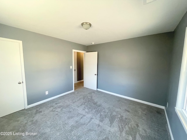 unfurnished bedroom featuring carpet and baseboards