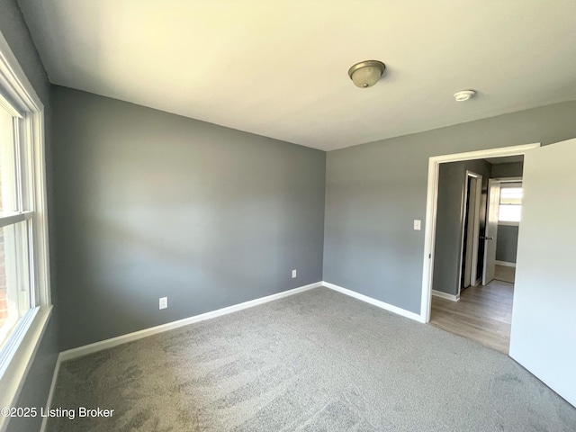 carpeted empty room with baseboards