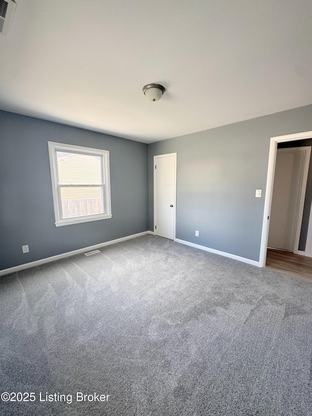 carpeted empty room featuring visible vents and baseboards