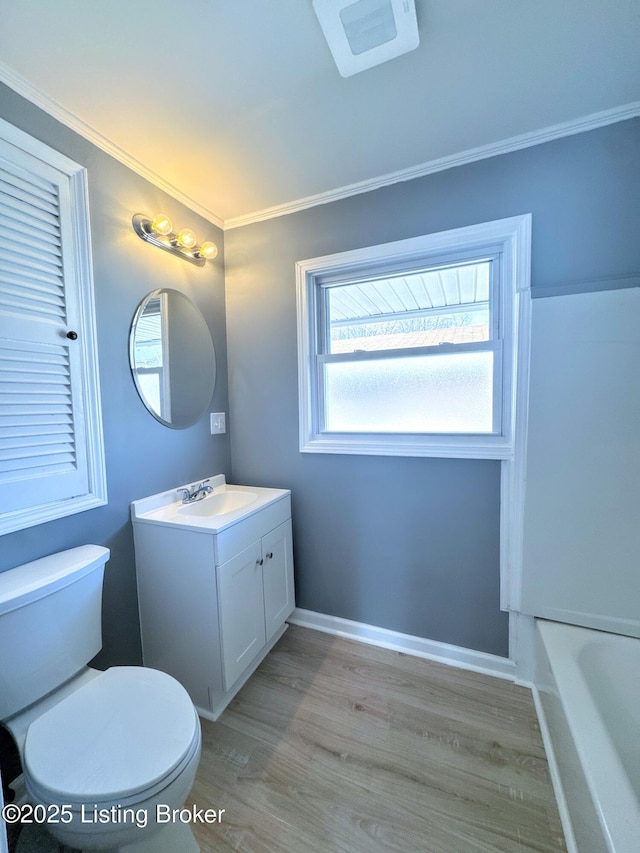 full bathroom featuring baseboards, toilet, wood finished floors, crown molding, and vanity