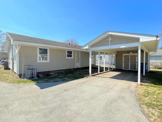 manufactured / mobile home featuring a carport, central AC, and driveway