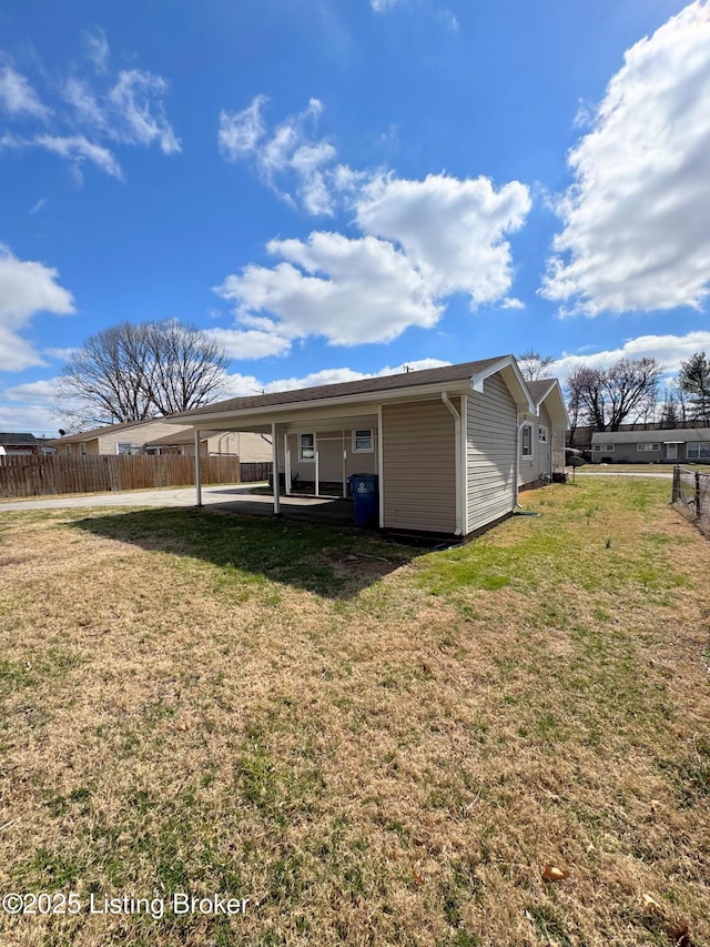 rear view of house with a lawn, a patio, and fence