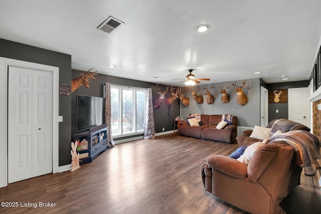 living room with visible vents, ceiling fan, baseboards, and wood finished floors