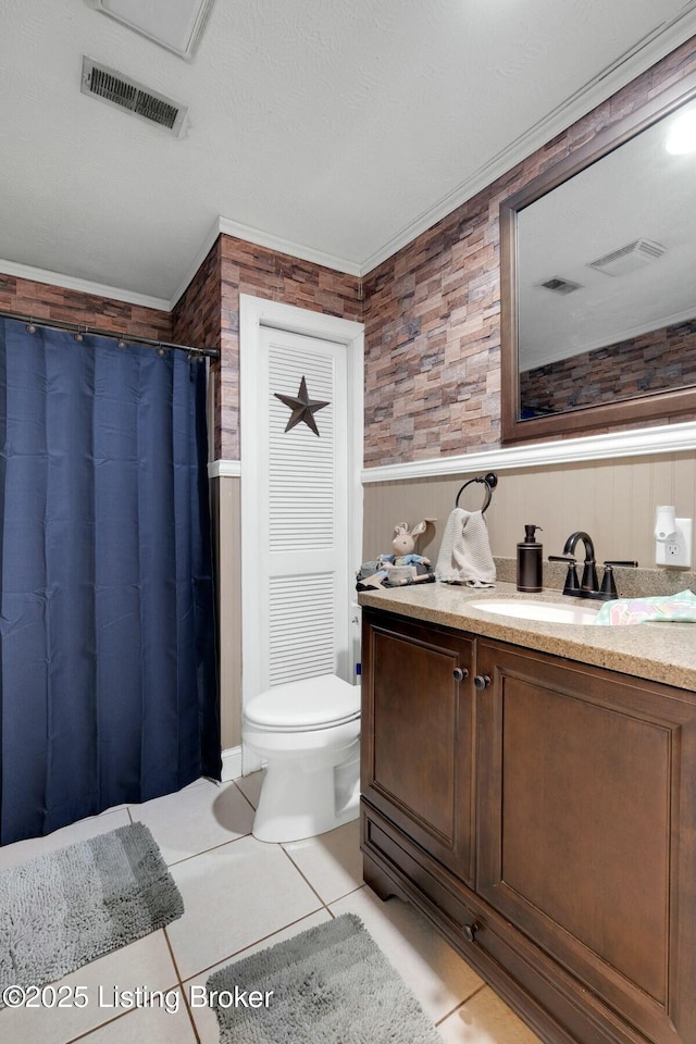 full bathroom with visible vents, toilet, wainscoting, vanity, and tile patterned flooring